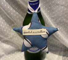 Load image into Gallery viewer, A softly padded star or heart with looped ribbon - so perfect for hanging around the bottle of something when gifting.  They can then choose where to hang it afterwards.  Choose your message - 'Dad in a Million', 'Grandad in a Million' or 'Happy Father's Day'  Fabric options are - grey stars, football, Union Jack or rugby - I have many more options so please use the 'Contact Us' page if you would like to discuss these.